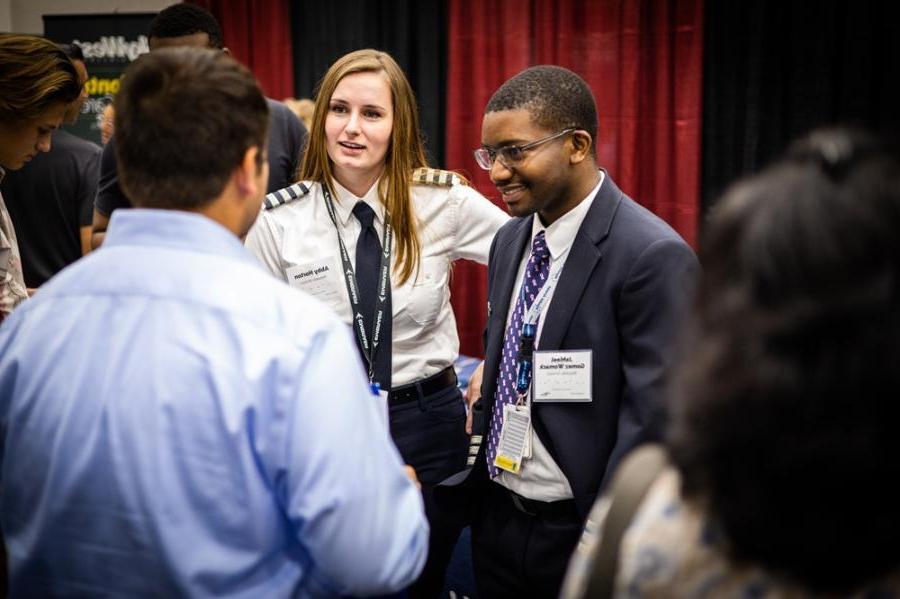 Representatives from multiple airlines speak with students at the aeronautics career fair.